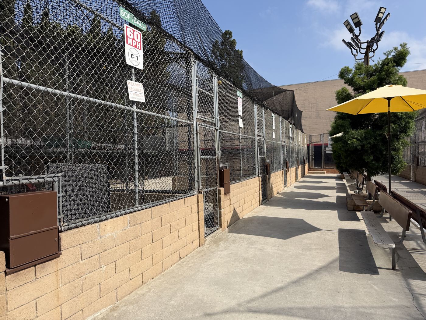 Shaded seating and umbrellas next to the batting cages
