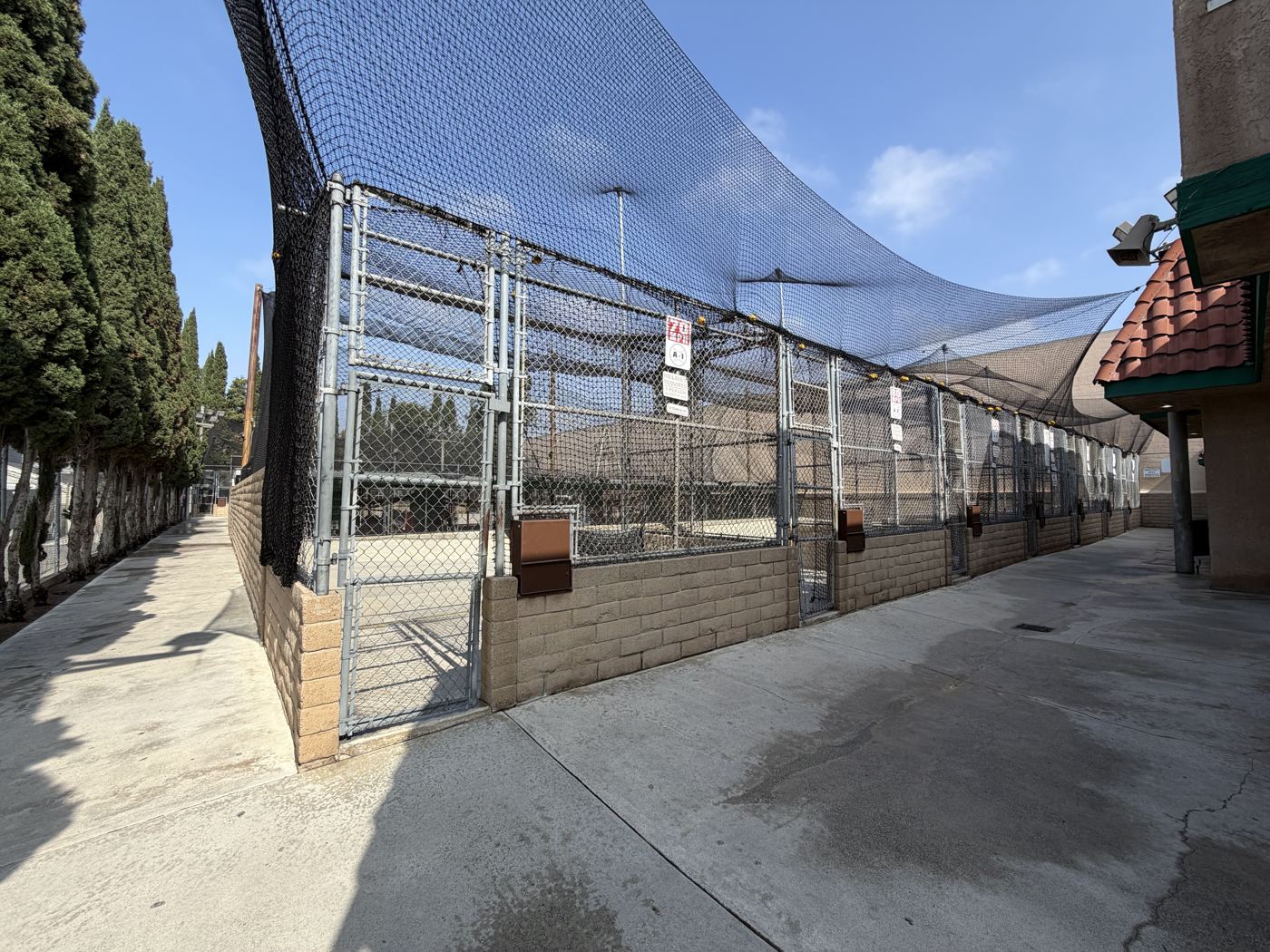 Long lane between batting cage stalls covered by netting