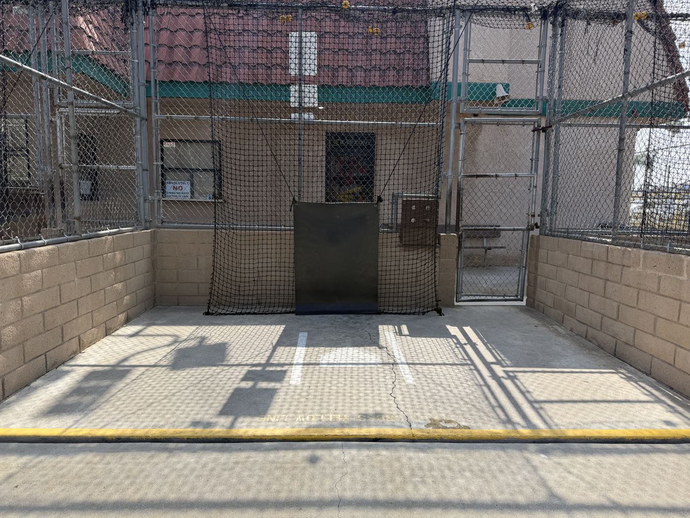 Inside a batting cage stall, looking down the lane from home plate